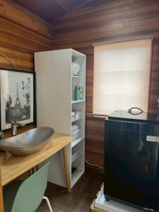 a bathroom with a sink and a television at Attico Inn ムーミン公園近く in Hanno