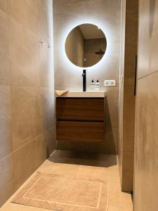 a bathroom with a sink and a mirror at Appartement Ocean Breeze Nes Ameland in Nes +11 photos