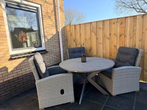 a table and two chairs on a patio at Appartement Ocean Breeze Nes Ameland in Nes