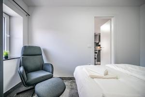 a bedroom with a chair and a bed at MVSV Apartment in Kamnik