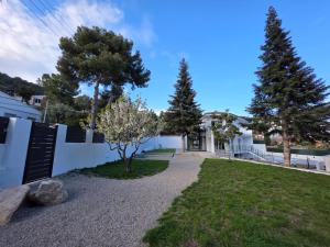 a yard with trees and a white building at Casablanca-Private Family Mountain Home in El Amunt