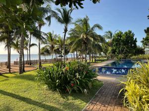 a resort with a swimming pool and palm trees and the ocean at Royal Wave, Beachfront, Nilaveli in Trincomalee