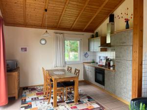 a kitchen with a table and chairs in a room at Haus Feldblick auf Rügen in Garz +1 photo