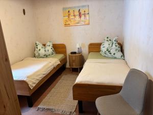 a room with two beds and a chair in it at Haus Feldblick auf Rügen in Garz
