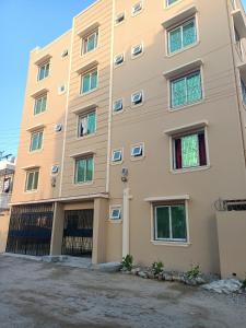 a large tan building with many windows at Ardina Studio in Mtwapa