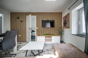 a living room with a table and a tv on a wall at MVSV Apartment in Kamnik