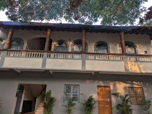 a large white house with a balcony at Artjuna CoLiving in Assagao