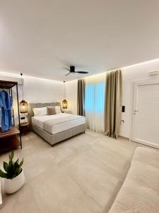 a large white bedroom with a bed and a couch at Alexis Suites Olympus in Litochoro