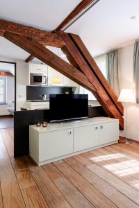 a living room with a tv on a white cabinet at Buhlsche Mühle in Ettlingen