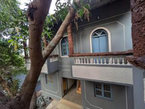 a building with a blue window and a tree at Artjuna CoLiving in Assagao +6 photos