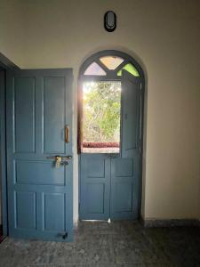 a blue door in a room with a window at Artjuna CoLiving in Assagao