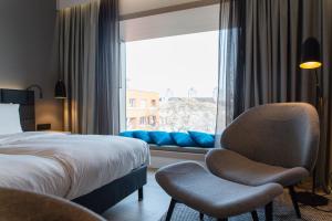 a bedroom with a bed and a chair and a window at Radisson Blu Hotel, Mannheim in Mannheim +79 photos