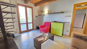 a living room with a red chair and a green cabinet at La Nocina in Raggio