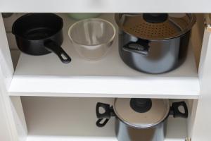 a shelf with some pots and pans on it at Monteurapartments in Heidenheim NEU Küche Smart TV WIFI in Heidenheim an der Brenz