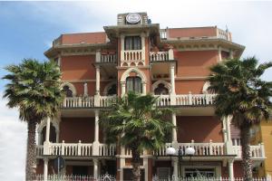 un gran edificio naranja con un reloj encima en Hotel Doria en Chiavari