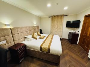 a hotel room with a bed and a flat screen tv at The Royal Hotel Elgin in Elgin