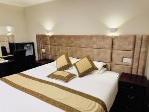 a bedroom with a large bed with two pillows on it at The Royal Hotel Elgin in Elgin
