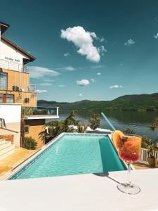 a swimming pool on a patio with a chair and water at Riviera 990 - Resort & Restaurant in Eşelniţa