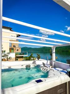 a hot tub on a patio with a view of the water at Riviera 990 - Resort & Restaurant in Eşelniţa