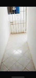 a room with a gate and a white tile floor at Hotel center in Las Terrenas
