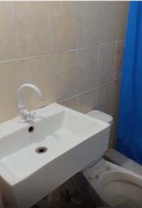 a bathroom with a white sink and a toilet at Hotel center in Las Terrenas