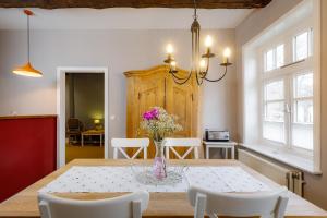 a dining room with a table with a vase of flowers at Brauhaus am Schloss in Gartow