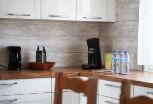 a kitchen counter with bottles of water and a coffee maker at Le Petit Orme in Chartres