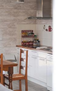 a kitchen with white cabinets and a counter with a table at Le Petit Orme in Chartres