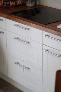 a kitchen counter with white drawers and a microwave at Le Petit Orme in Chartres