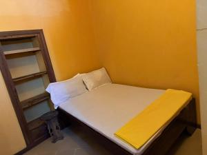 a small room with a bed and a shelf at Busara house 2 in Zanzibar City +7 photos