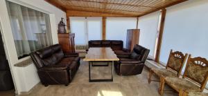 a living room with leather chairs and a wooden table at Bungalow Helga in Fürstenwalde