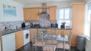 a kitchen with a sink and a table with chairs at Rock Quay in Killyleagh