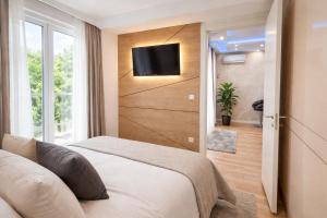 a bedroom with a bed and a tv on a wall at Extra Apartman in Banja Luka