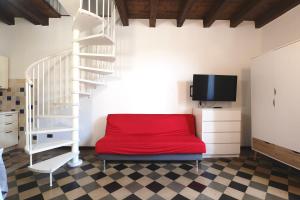 a room with a red bed and a white staircase at Casa Angela Apartments in Bergamo