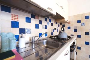 a kitchen with a sink and blue and white tiles at Casa Angela Apartments in Bergamo +66 photos