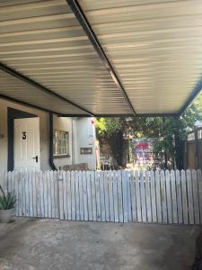 a white picket fence in front of a house at Cottage on Kort Deluxe in Parys