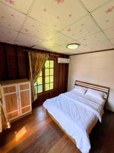 a bedroom with a large bed in a room at Cozy Beach House , 5 mn from the Sea -Self Check in in Ban Laem Sai