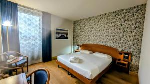 a bedroom with a bed and a table and a desk at Hotel Le Cerbaie in Altopascio