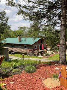 a log cabin with a green roof at Roscoe Cabin Pet friendly in Roscoe