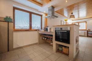a large kitchen with a large television and a counter at Tatry TOP Dom in Vavrišovo +50 photos