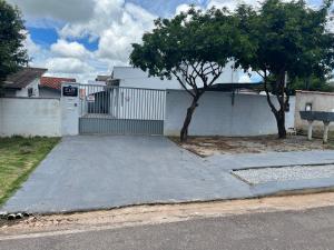 a driveway in front of a house with a gate at Apartamento Aconchego II in Alta Floresta