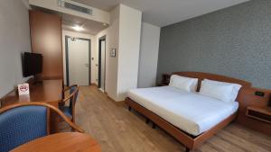 a hotel room with a bed and a desk and a table at Hotel Le Cerbaie in Altopascio