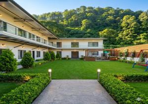 a house with a large yard with a playground at Qcent Bairagarh Resort Rishikesh in Mohan Chatti