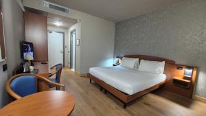 a hotel room with a bed and a table at Hotel Le Cerbaie in Altopascio