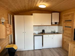 a kitchen with white cabinets and a sink at Domki Skowronki in Kąty Rybackie +48 photos