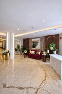a lobby with a red couch in a building at Hotel Ramhan Palace in New Delhi
