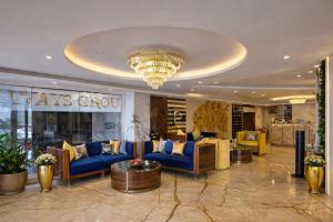 a lobby with blue couches and a chandelier at Hotel Ramhan Palace in New Delhi