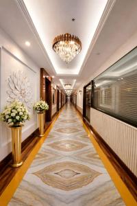 a hallway with a large rug in a building with a chandelier at Hotel Ramhan Palace in New Delhi +74 photos