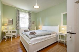 a bedroom with a bed and two chairs and a window at Brauhaus am See in Gartow