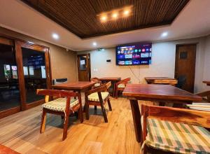 a restaurant with wooden tables and chairs and a screen at Casa Nuna in Tilcara